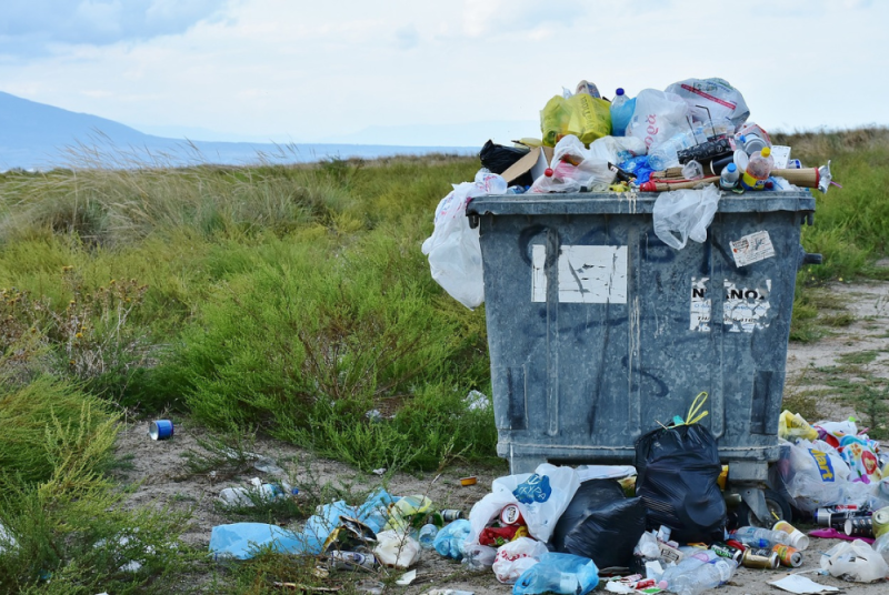 A bin full of rubbish in the countryside