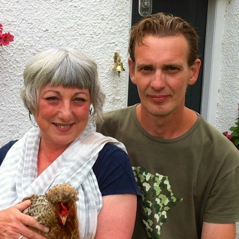Man and a woman holding a hen